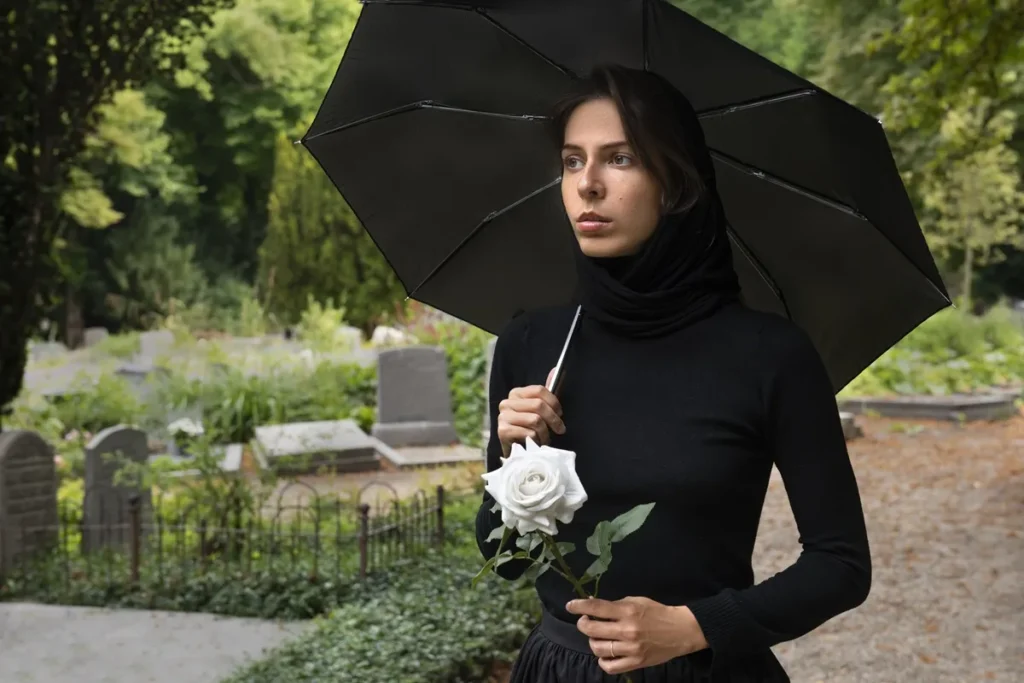 Donna a un funerale con la pioggia