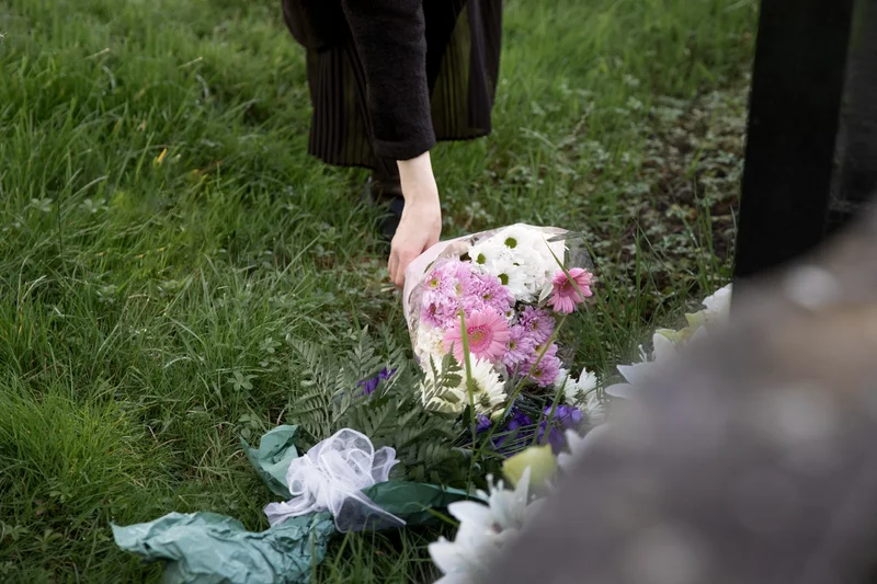 Fiori posti su bara durante funerale al mattino